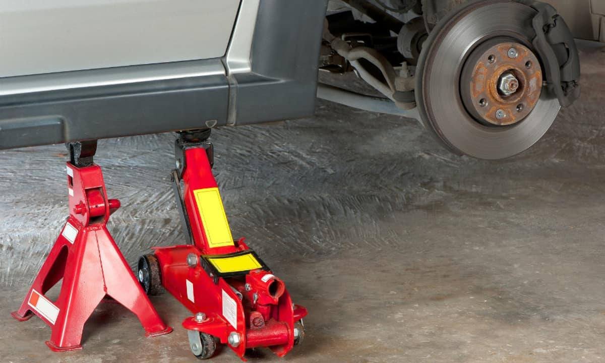 Floor jack and jack stand supporting a car