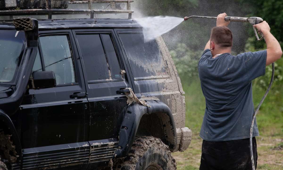 Man washing muddy SUV with best pressure washer for cars